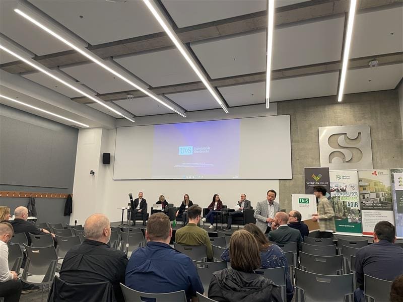 "Une table ronde est en cours dans une salle de conférence moderne où six personnes sont assises sur la scène. Accueillis par Nature Québec