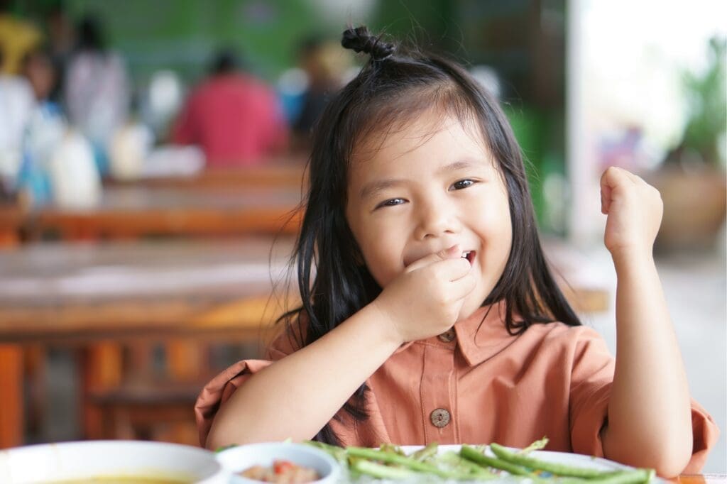 Une élève du primaire savoure un menu de santé planétaire.