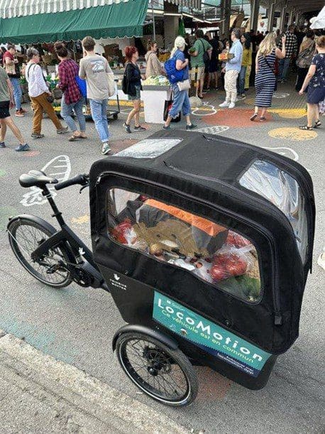 Un vélo locomotion avec une remorque adapté pour les courses