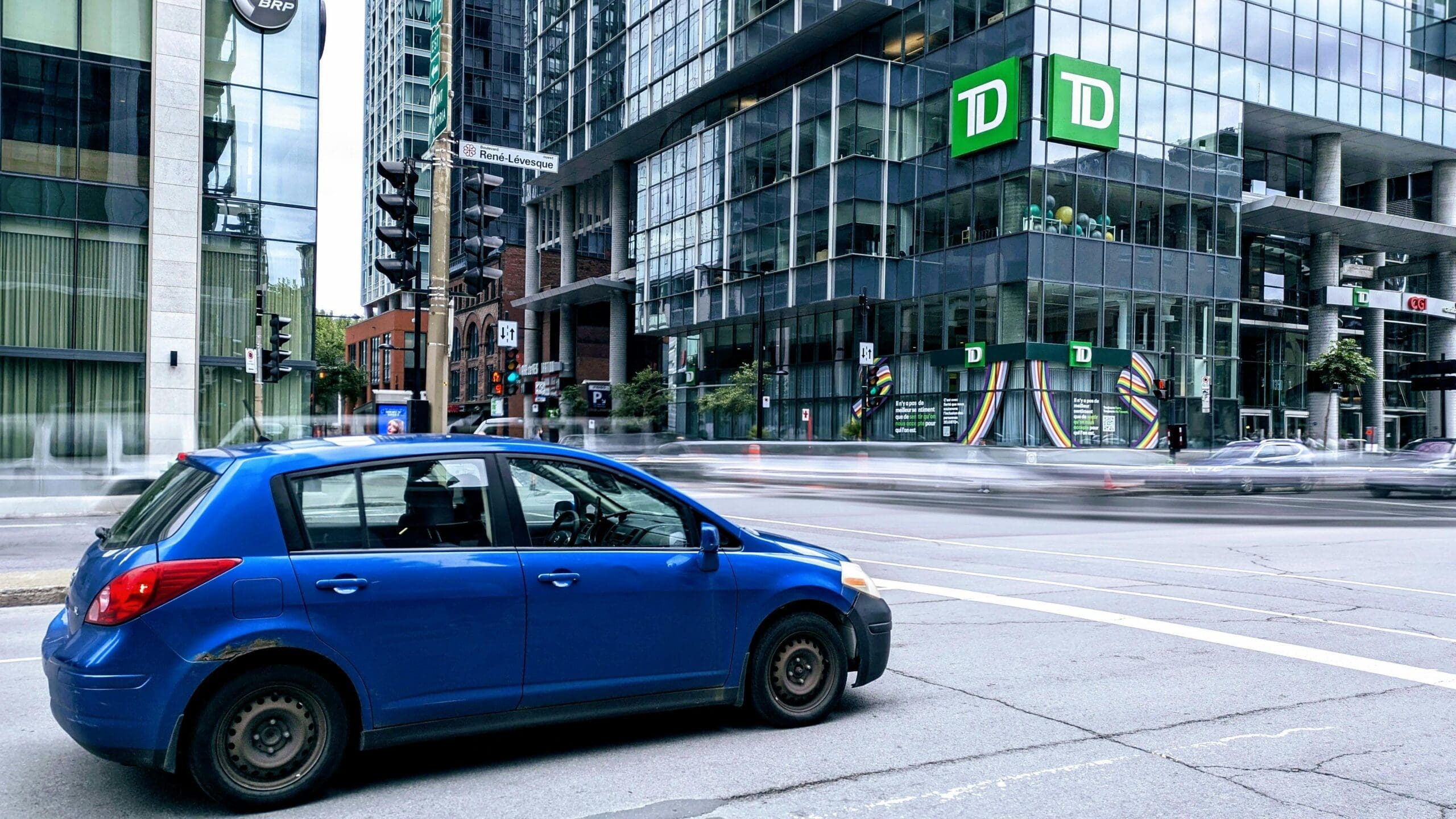 Une voiture bleu circule sur l'avenue René-Lévesque à Montréal